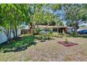 Spacious front yard with mature trees, providing shade and enhancing the property's appeal at 1530 Erin Ln, Clearwater, FL 33755