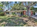 Ranch-style home with a mature tree, well-maintained lawn, and inviting curb appeal at 1530 Erin Ln, Clearwater, FL 33755