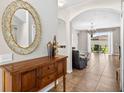 Inviting entryway featuring tile floors, a wooden console table and an arched doorway at 19028 Narimore Dr, Land O Lakes, FL 34638