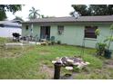 A backyard with grass, patio set, grill, and a fire pit area for outdoor enjoyment and entertainment at 2058 Dodge St, Clearwater, FL 33760