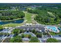 Beautiful aerial view showcasing the community golf course, clubhouse, pool, and lush landscaping at 21248 Diamonte Dr, Land O Lakes, FL 34637