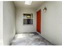 Inviting front porch featuring unique stone flooring and a vibrant orange door at 21248 Diamonte Dr, Land O Lakes, FL 34637