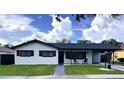 Inviting home with a covered carport, rocking chairs, and a lush green lawn at 2509 Thornbrook Pl, Tampa, FL 33618