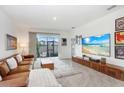 Bright living room with a modern entertainment center, large windows, and comfortable furniture, perfect for relaxation at 31426 Ancient Sage Rd, Wesley Chapel, FL 33545