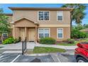 Inviting tan condo exterior featuring a quaint, covered entryway and well-manicured landscaping at 36243 Lake Chase Blvd # 102, Zephyrhills, FL 33541