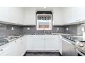 Beautiful kitchen featuring white cabinets, granite countertops, grey tile backsplash, and stainless steel appliances at 3628 Holiday Lake Dr, Holiday, FL 34691