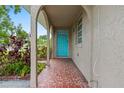 The spacious covered front porch welcomes visitors with decorative tile flooring and a pop of color from the bright turquoise door at 3909 W Lemon St, Tampa, FL 33609