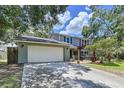 Two-story home featuring a two-car garage, a welcoming pergola, and beautifully landscaped front yard at 4030 Braesgate Ln, Tampa, FL 33624
