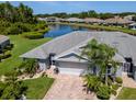 A lovely single Gathering home overlooking a pond, featuring palm trees and manicured landscaping in a peaceful residential neighborhood at 717 Manchester Woods Dr # 717, Sun City Center, FL 33573