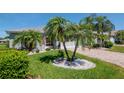 A beautiful single-Gathering home with well-maintained landscaping, a brick driveway, and mature palm trees at 717 Manchester Woods Dr # 717, Sun City Center, FL 33573