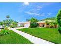 View of a well-manicured lawn and landscaping leading to a charming home with a white garage door at 11116 118Th St, Seminole, FL 33778