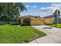 Charming single-Gathering home with a lush green lawn, mature trees, and a two-car garage at 11125 Shelter Cove Loop, New Port Richey, FL 34654
