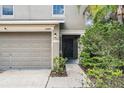 Close up of the exterior featuring a two-car garage and a covered front entryway at 15420 Quail Woods Pl, Ruskin, FL 33573