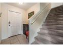Inviting home foyer with staircase, tile flooring, and a white front door at 15420 Quail Woods Pl, Ruskin, FL 33573