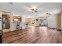 Open-concept living room and kitchen with wood flooring, ceiling fans, and patio access at 15420 Quail Woods Pl, Ruskin, FL 33573
