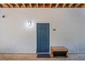 Exterior shot of a blue unit front door with black mat, wooden floors and a wall light at 1640 Villa Capri Cir # 206, Odessa, FL 33556