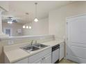 Neutral kitchen featuring stainless steel sink, white cabinets and a modern dishwasher at 1640 Villa Capri Cir # 206, Odessa, FL 33556