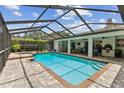Inviting screened-in pool area featuring a sparkling blue pool, covered patio, and ample space for relaxation at 1810 Tamerlane Pl, Brandon, FL 33510