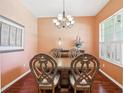 Elegant dining room featuring a chandelier, hardwood floors, and a table with decorative chairs at 25950 Risen Star Dr, Wesley Chapel, FL 33544
