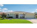 Charming single story home featuring manicured landscaping, covered entry, and a two-car garage at 25950 Risen Star Dr, Wesley Chapel, FL 33544