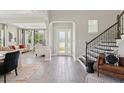 Elegant foyer with wood-look flooring, staircase, and open view to the living room at 2903 Cordoba Ranch Blvd, Lutz, FL 33559