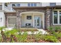 Inviting front porch with stone accents, a cozy bench, and lush landscaping at 2903 Cordoba Ranch Blvd, Lutz, FL 33559