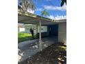 View of the carport with a peek at the home's facade and surrounding greenery under a bright sky at 3111 S Canal Dr, Palm Harbor, FL 34684