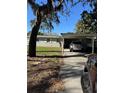 Exterior view of a one-story home with a covered carport and well-kept lawn on a sunny day at 3111 S Canal Dr, Palm Harbor, FL 34684