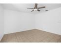 Minimalist bedroom with neutral walls, tiled floor and a modern ceiling fan at 312 E Tomlin St, Plant City, FL 33563