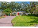 Inviting single-story home with well-manicured lawn, brick driveway, solar panels, and cheerful yellow siding at 3129 W Villa Rosa St, Tampa, FL 33611