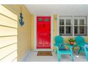 Close-up of the entrance with a vibrant red door and cozy seating area, enhanced by nautical decor at 3129 W Villa Rosa St, Tampa, FL 33611