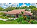 Charming brick home with well-manicured lawn, trimmed shrubs, and beautiful landscaping at 3923 Hudson Ln, Tampa, FL 33618
