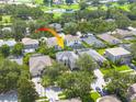Aerial view of a two-story home nestled in a neighborhood with mature trees at 4147 Grandchamp Cir, Palm Harbor, FL 34685