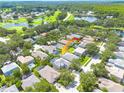 Aerial view of a home in a neighborhood with mature trees and ponds at 4147 Grandchamp Cir, Palm Harbor, FL 34685