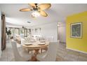 Bright dining room with a table, ceiling fan, and view into the living room at 5623 80Th N St # 415, St Petersburg, FL 33709