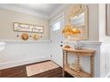 Welcoming foyer with wainscoting, dark floors, a decorative mirror, and coastal accents at 58 Aster St, Clearwater Beach, FL 33767
