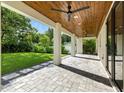 Covered outdoor patio with stone pavers, wooden ceiling, and a view of the expansive green yard at 5816 S 3Rd St, Tampa, FL 33611