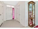 Bright entryway with tile flooring, a coat closet and a decorative display cabinet at 6231 Olivedale Dr, Riverview, FL 33578