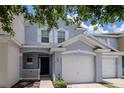 Charming townhome featuring light blue exterior paint, white trim, and a one-car garage at 6231 Olivedale Dr, Riverview, FL 33578