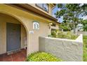 Inviting condo entrance with gray door, decorative accents, and well-maintained landscaping at 6262 142Nd N Ave # 1302, Clearwater, FL 33760