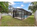 Backyard view featuring a screened-in pool area, offering a relaxing and private outdoor space at 6706 Dunes Ln, Temple Terrace, FL 33617