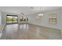 Bright living room with wood floors, multiple windows, and sliding glass doors to the backyard at 7408 Sungold Meadow Ct, Apollo Beach, FL 33572