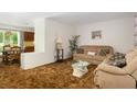 Comfortable living room featuring a cozy sofa, plush armchair and large decorative pillows at 760 72Nd N Ave, St Petersburg, FL 33702