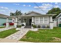 Charming home featuring a quaint front porch, freshly painted exterior, and beautifully manicured landscaping at 904 E Hamilton Ave, Tampa, FL 33604