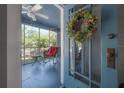 Cozy screened porch featuring a red rocking chair and a view of the outdoors at 917 W Idlewild Ave, Tampa, FL 33604