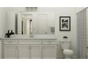 Bathroom with a double sink vanity, neutral paint, framed artwork and tiled shower with curtain at 9542 Minnow Ray Dr, Land O Lakes, FL 34638
