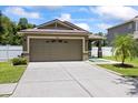Inviting front exterior showcases a well-maintained lawn, a spacious driveway, and an attached two-car garage at 9831 Edmonton Dr, Land O Lakes, FL 34638