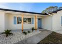 Inviting front entrance with decorative columns, blue door, charming shutters and decorative rock landscaping at 105 12Th Sw St, Ruskin, FL 33570