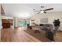 Spacious living room with hardwood floors, a ceiling fan, and sliding glass doors to the backyard pool at 12038 Steppingstone Blvd, Tampa, FL 33635
