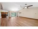 Spacious living room with hardwood floors, a ceiling fan, and sliding glass doors to the backyard pool at 12038 Steppingstone Blvd, Tampa, FL 33635